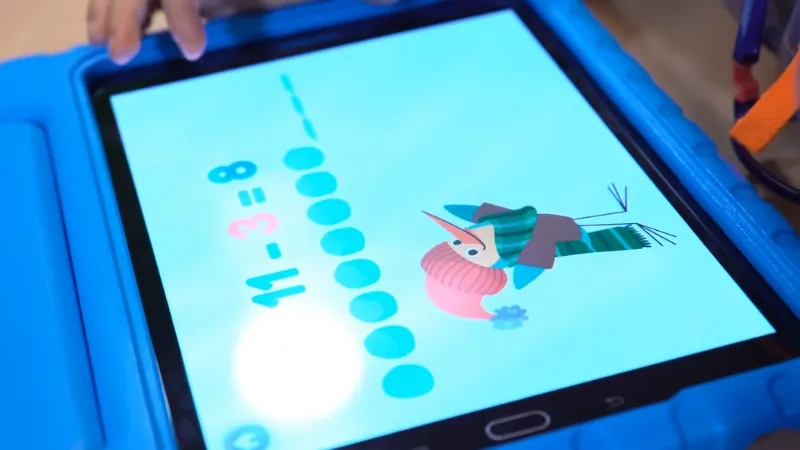 A child uses a tablet to solve a subtraction problem in one of the free math games online designed for early learners