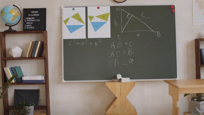 A classroom chalkboard displays geometric formulas and diagrams