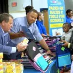 Community members gather to receive school supplies