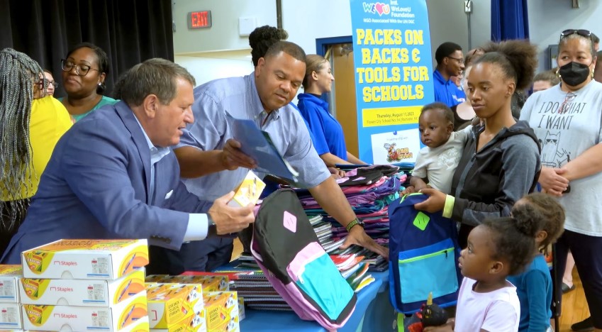 Community members gather to receive school supplies