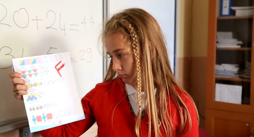 A close-up view of a child's graded worksheet, showcasing a "F" grade