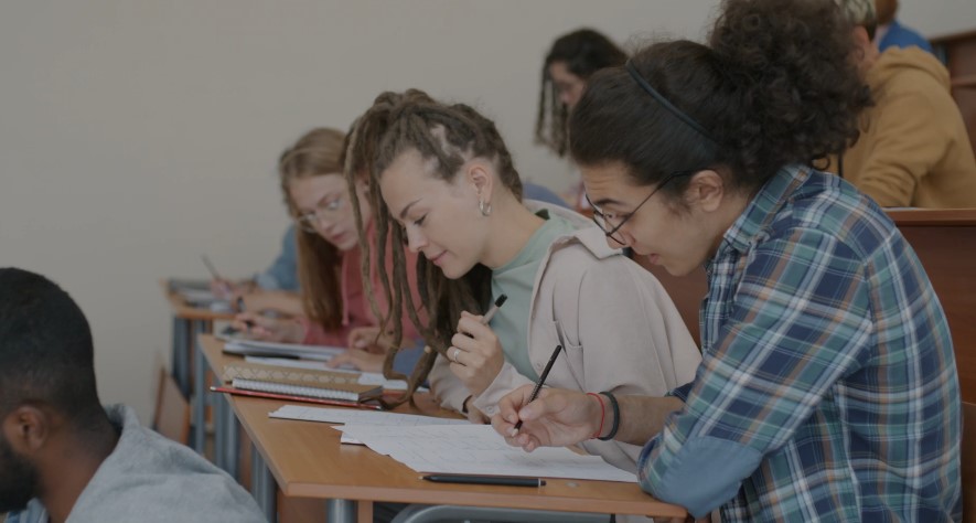Focused students diligently working on exam papers in a classroom setting