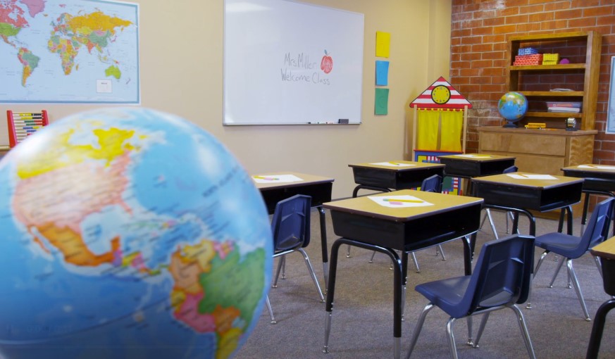 Empty desks and chairs in a well-lit classroom