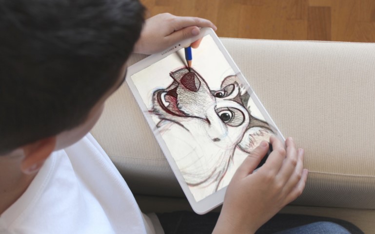 Kid watching tutorial on how to draw a dog, on his tablet
