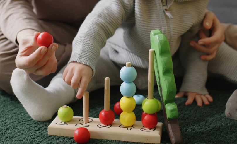 A child and adult engage in a playful learning activity