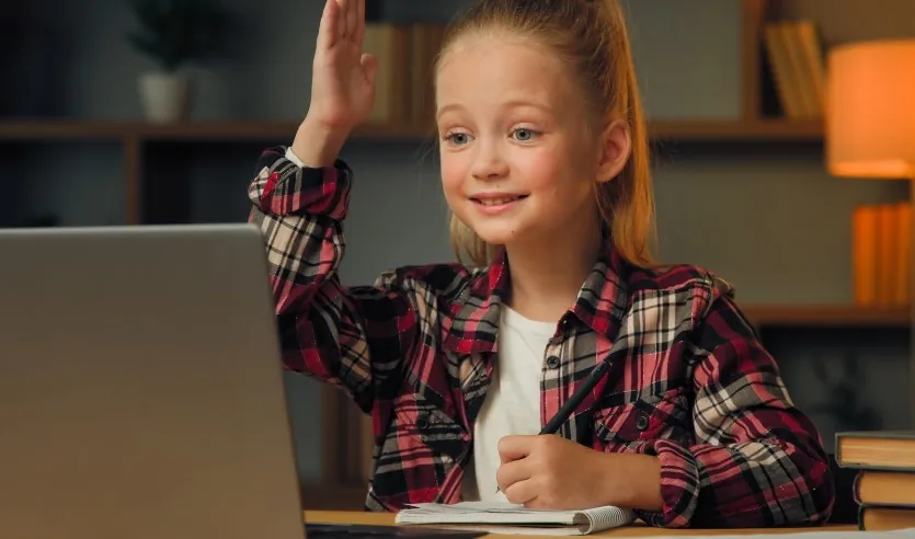 A young girl sits at a desk, engaged in a digital learning experience