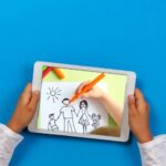 Child's hands hold a tablet, digitally drawing a family portrait