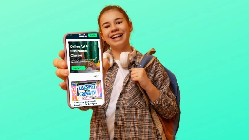 Smiling teen holds up a phone, highlighting custom learning for a lasting impact
