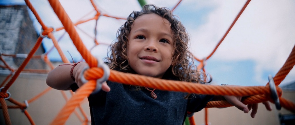 Child helping a friend up from the ground in playground