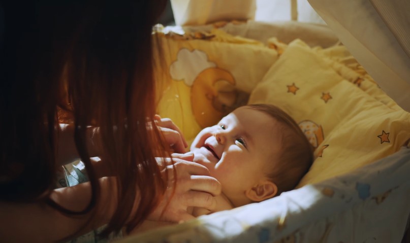Mom plays with baby, making baby smile