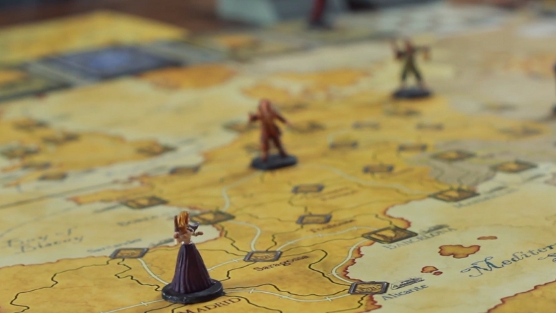 Miniature figures move across a detailed map of Europe in the Fury of Dracula board game during active gameplay