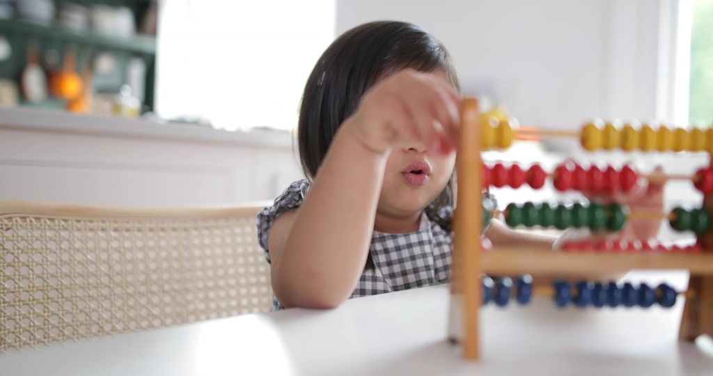Child stacking number blocks and counting aloud