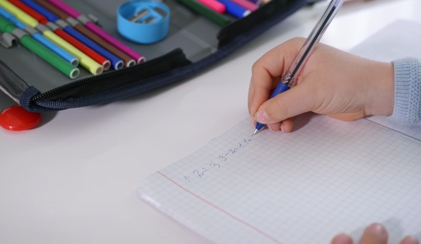 Close-up view of a student's hand solving math equations