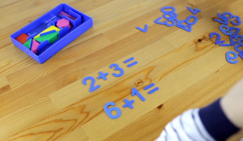 Colorful shapes and numbers arranged on a light wooden surface