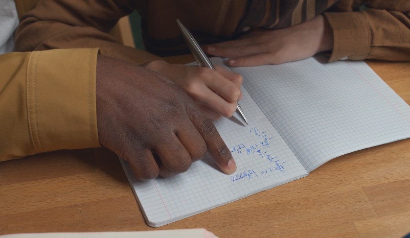 Close-up of hands working on a math problem, highlighting the focus and concentration
