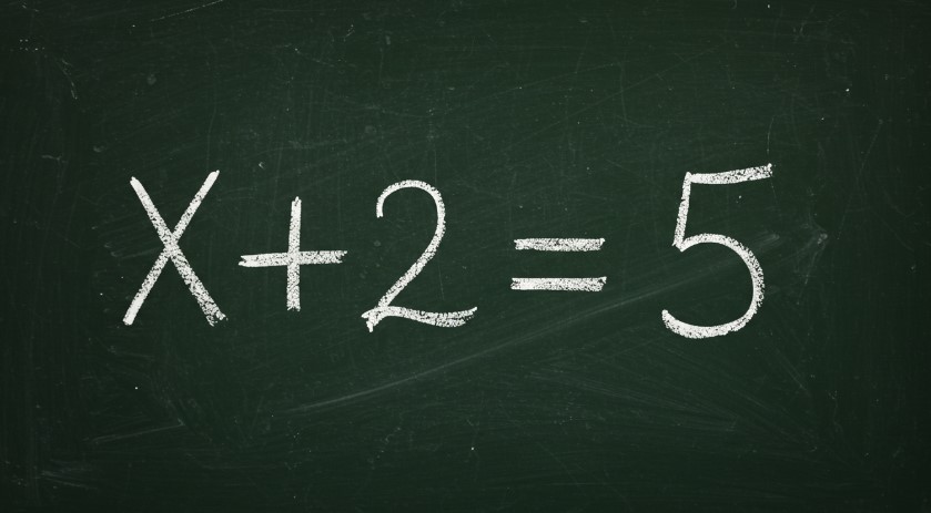 The equation x + 2 = 5 is written in chalk on a green chalkboard