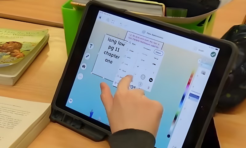 Student using SeaSaw app on a tablet during a class